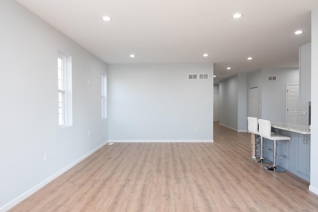 unfurnished room featuring light wood-style flooring, visible vents, baseboards, and recessed lighting