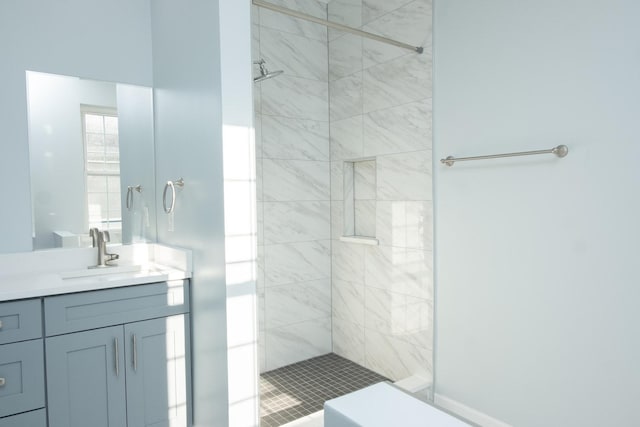 bathroom featuring a tile shower and vanity