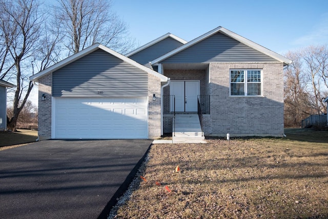 view of front of house featuring brick siding, driveway, and an attached garage