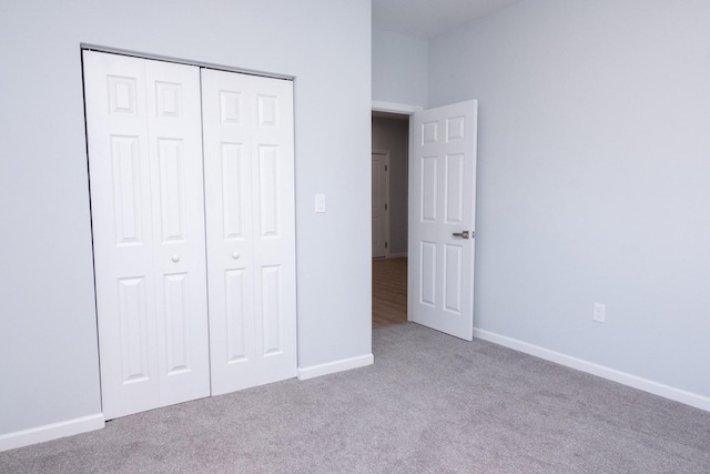 unfurnished bedroom with carpet floors, baseboards, and a closet