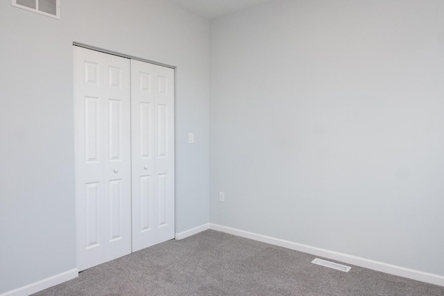 unfurnished bedroom featuring carpet, a closet, visible vents, and baseboards