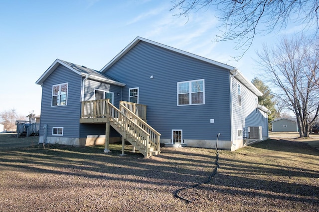 rear view of house with stairs, a deck, and a lawn