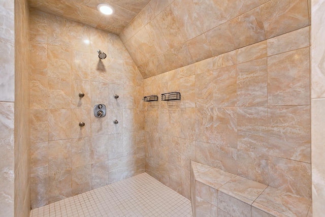 bathroom with lofted ceiling and tiled shower