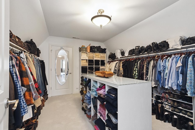 walk in closet with lofted ceiling and carpet