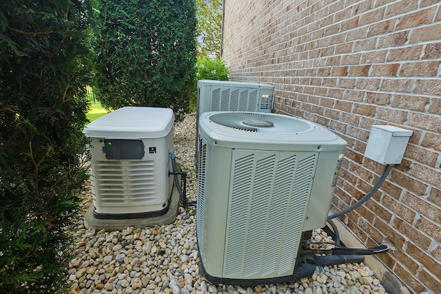 details with a power unit, brick siding, and cooling unit