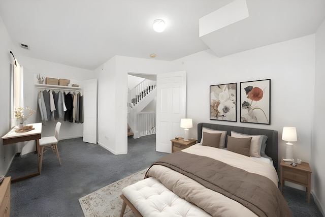 bedroom with a closet, dark carpet, and baseboards