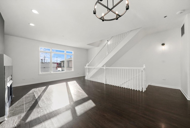 interior space with visible vents, a notable chandelier, baseboards, and wood finished floors