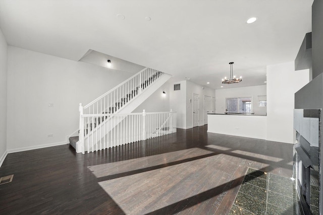 staircase with an inviting chandelier, wood finished floors, visible vents, and recessed lighting