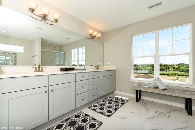 full bathroom with a marble finish shower, baseboards, visible vents, marble finish floor, and a sink