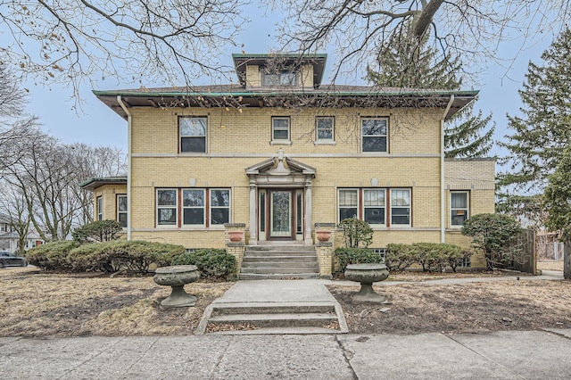 american foursquare style home featuring brick siding