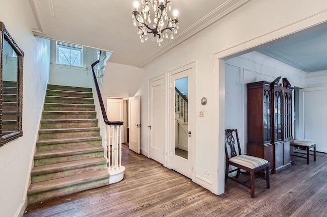 entrance foyer with stairs, wood finished floors, and crown molding