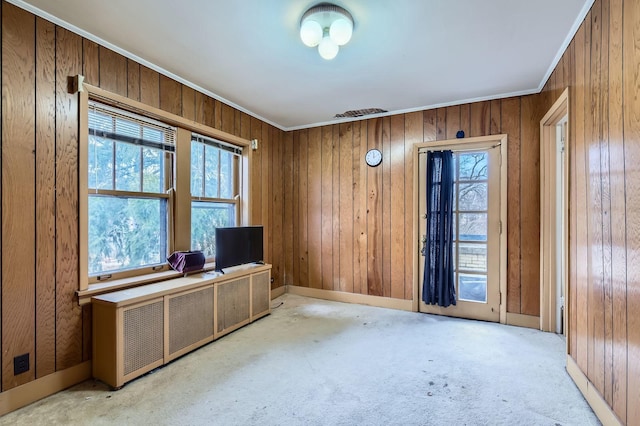 unfurnished office featuring wood walls, carpet, baseboards, and crown molding