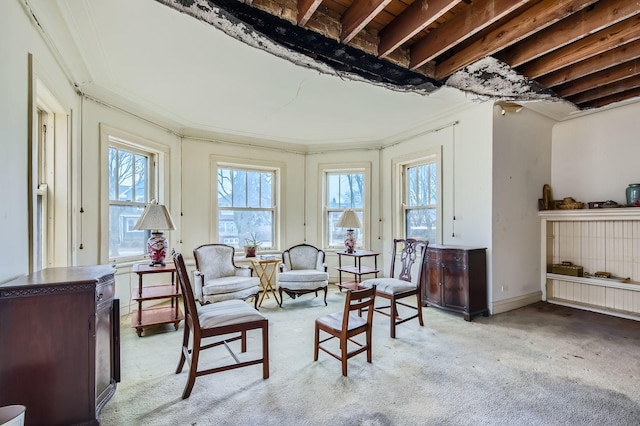 living area with crown molding, baseboards, and light colored carpet