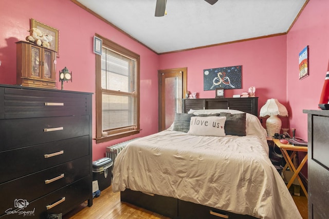 bedroom with radiator, ceiling fan, ornamental molding, and wood finished floors