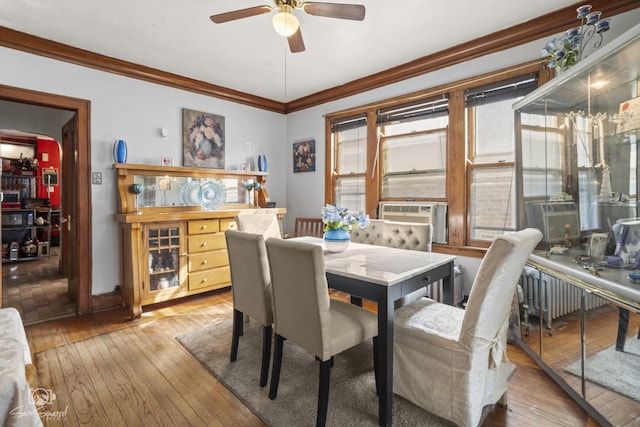 dining room with ornamental molding, cooling unit, and hardwood / wood-style flooring