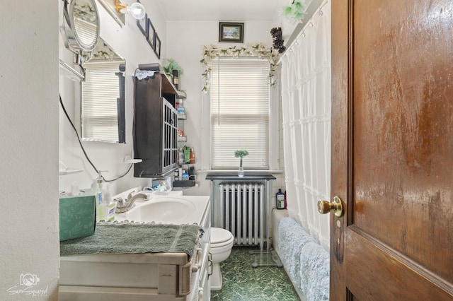 bathroom featuring vanity, toilet, and radiator