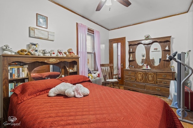 bedroom with ceiling fan, crown molding, and wood finished floors