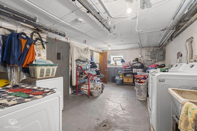 below grade area with electric panel, a sink, and washing machine and clothes dryer