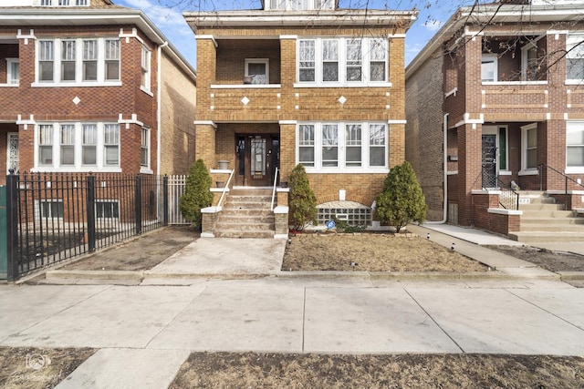 view of front facade with brick siding and fence