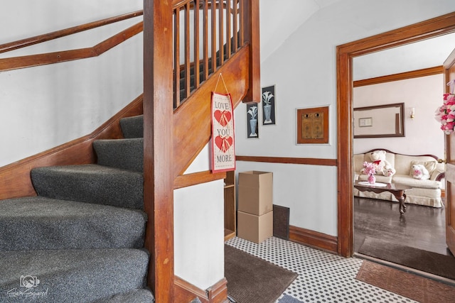 stairs with lofted ceiling and baseboards