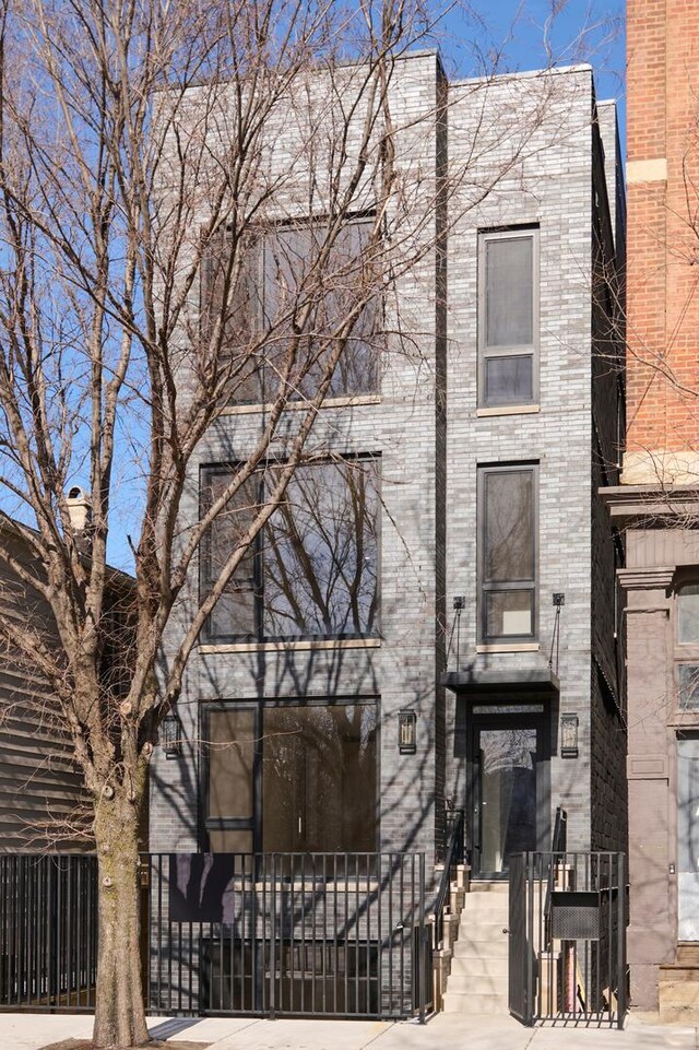 view of front of property with brick siding and fence private yard