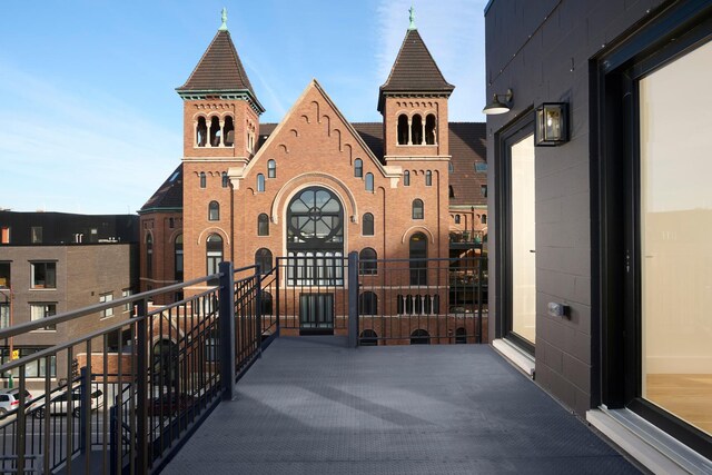 exterior space with brick siding and a balcony