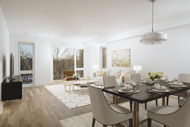 dining area featuring light wood-style floors and baseboards