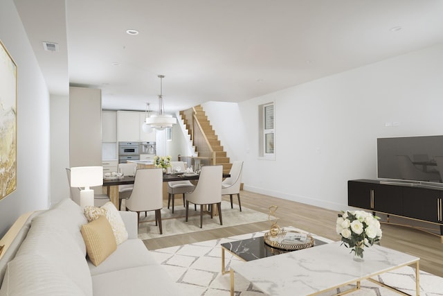 living area with recessed lighting, baseboards, light wood-type flooring, visible vents, and stairway