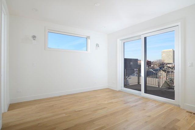 empty room featuring baseboards and light wood finished floors