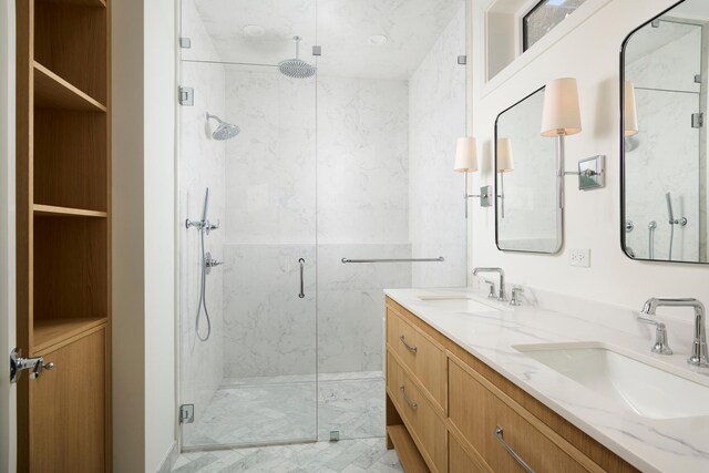 bathroom with a sink, a marble finish shower, double vanity, and marble finish floor