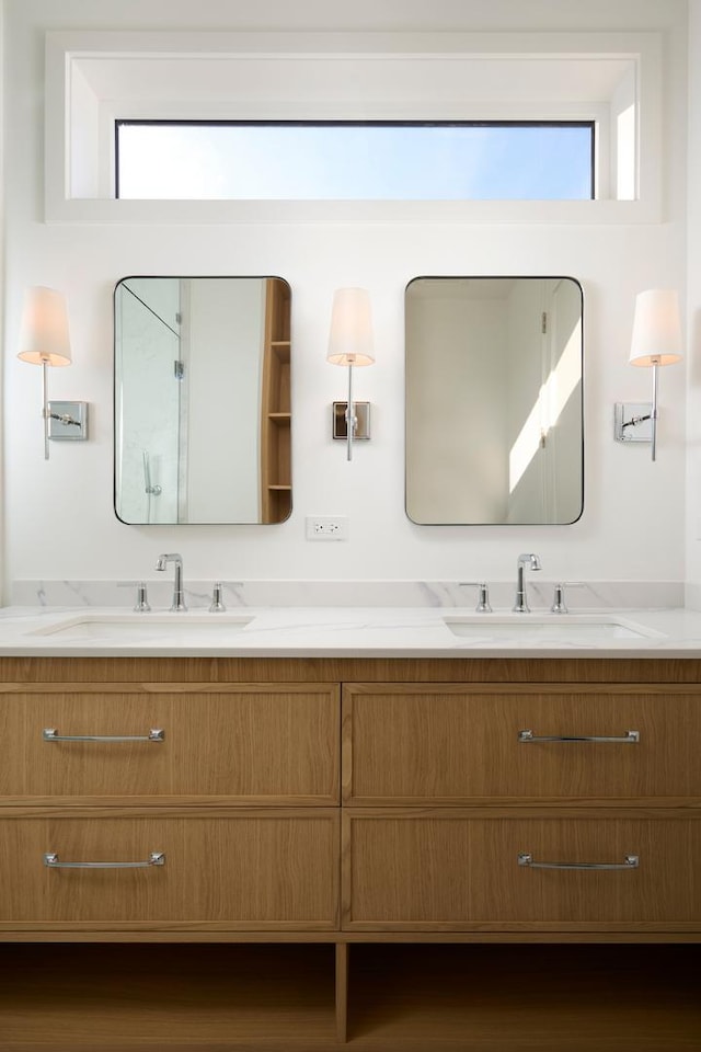 bathroom featuring double vanity, plenty of natural light, and a sink