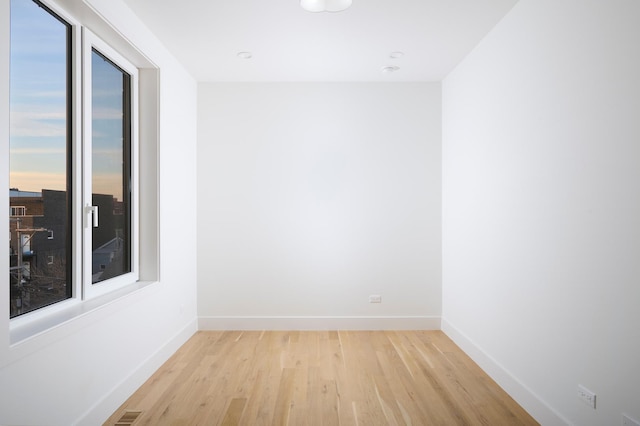 empty room with recessed lighting, baseboards, and light wood-type flooring