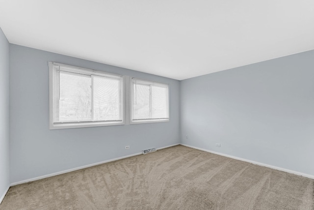 carpeted empty room with baseboards and visible vents