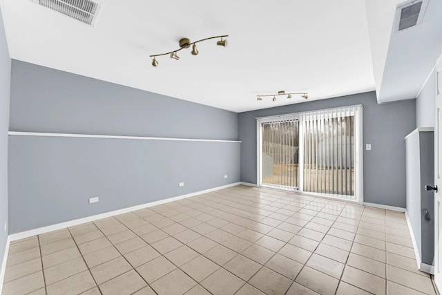 spare room with rail lighting, visible vents, and baseboards