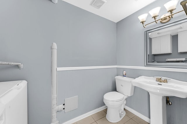 bathroom featuring toilet, tile patterned flooring, visible vents, and baseboards