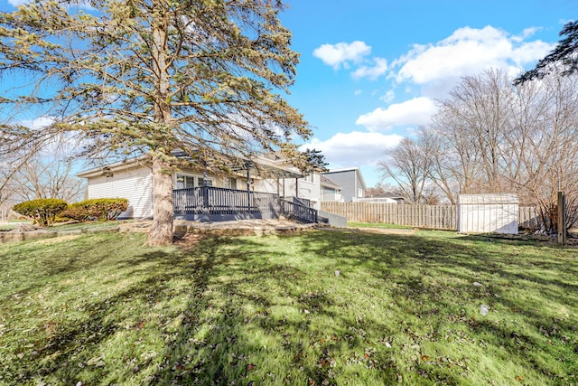 view of yard featuring an outbuilding, fence, and a storage shed