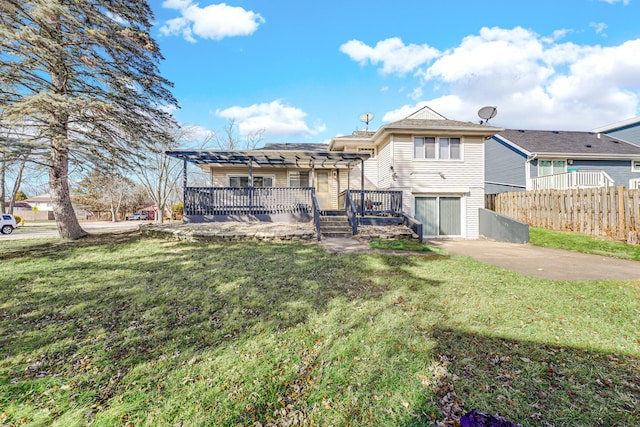 rear view of property with a yard, fence, and a wooden deck