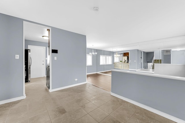 interior space featuring baseboards and a notable chandelier