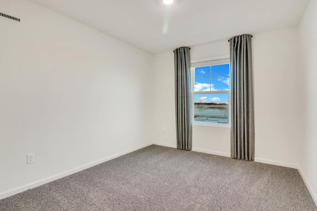 spare room with baseboards, visible vents, and carpet flooring