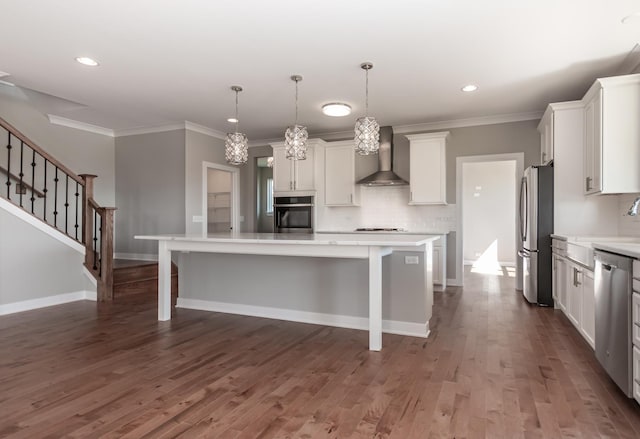 kitchen featuring wall chimney exhaust hood, a breakfast bar area, stainless steel appliances, and light countertops