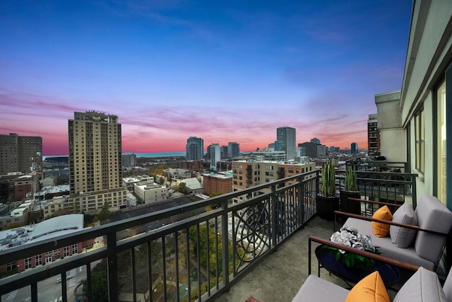 balcony at dusk featuring a view of city