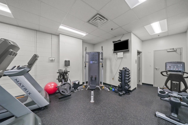 workout area featuring a drop ceiling, visible vents, and baseboards