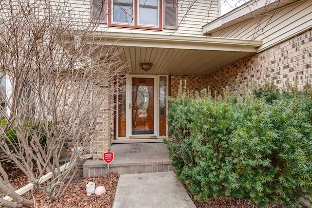 view of exterior entry featuring brick siding