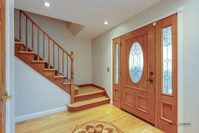 entrance foyer with stairs, baseboards, wood finished floors, and recessed lighting