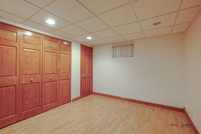 unfurnished bedroom with light wood-style floors, recessed lighting, a drop ceiling, and baseboards