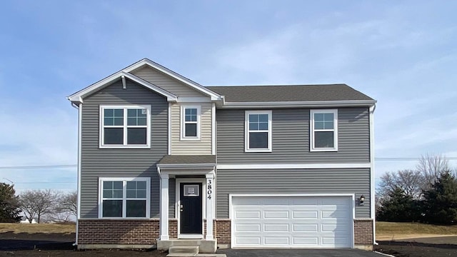 view of front of house with a garage, driveway, and brick siding