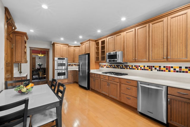 kitchen featuring appliances with stainless steel finishes, light countertops, and tasteful backsplash