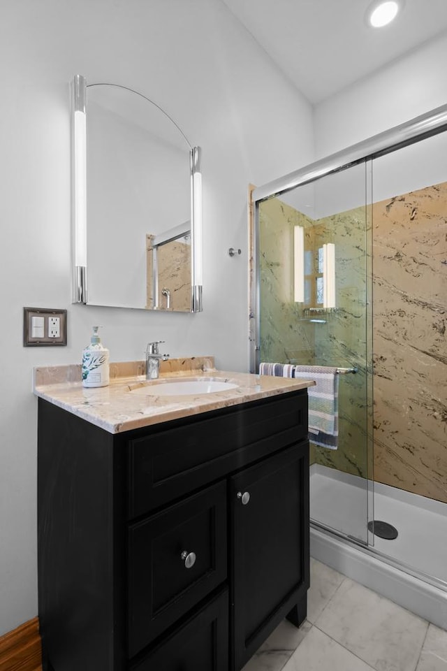 full bathroom featuring vanity and a marble finish shower