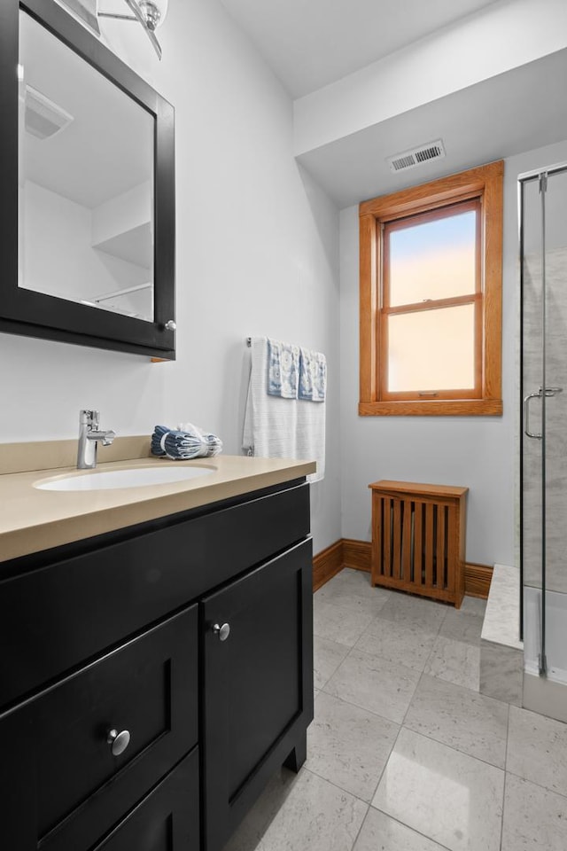 bathroom featuring a stall shower, visible vents, vanity, and baseboards