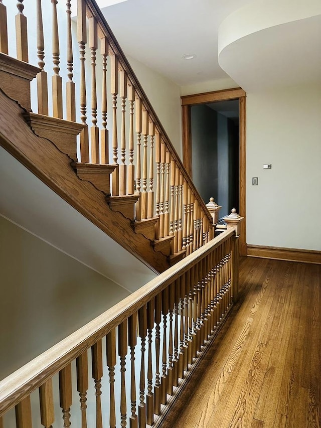 stairs featuring wood finished floors and baseboards